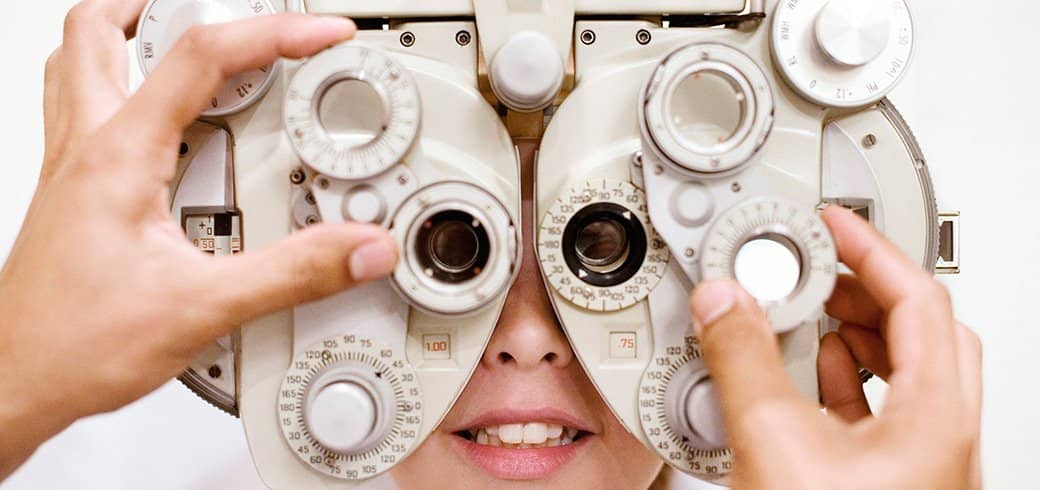 En optiker der justerer apparatet til øjenprøven